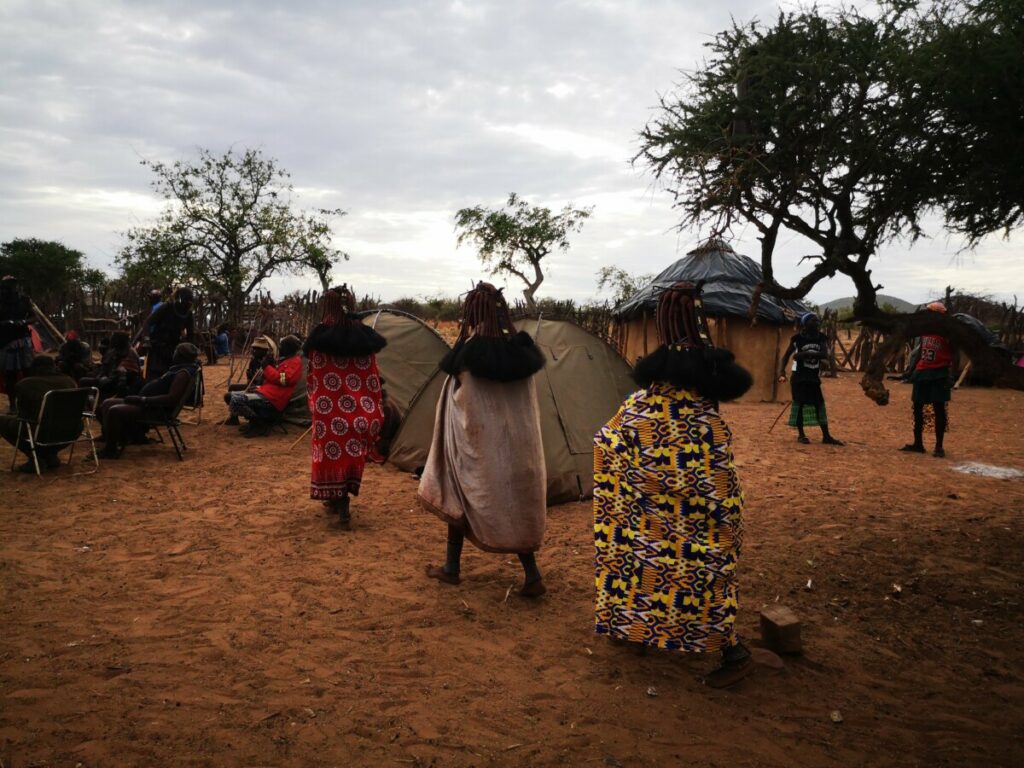 3 vrouwen lopen in een treintje naar de mannen - Himba Gewoontes 3 vrouwen lopen in een treintje naar de mannen - Himba Gewoontes