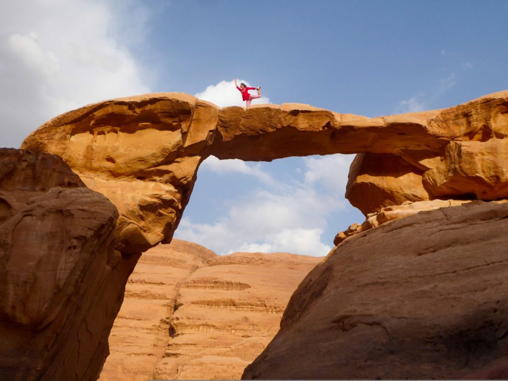 Yoga pose op de natuurlijke Um Fruth brug in de Wadi Rum Yoga pose op de natuurlijke Um Fruth brug in de Wadi Rum