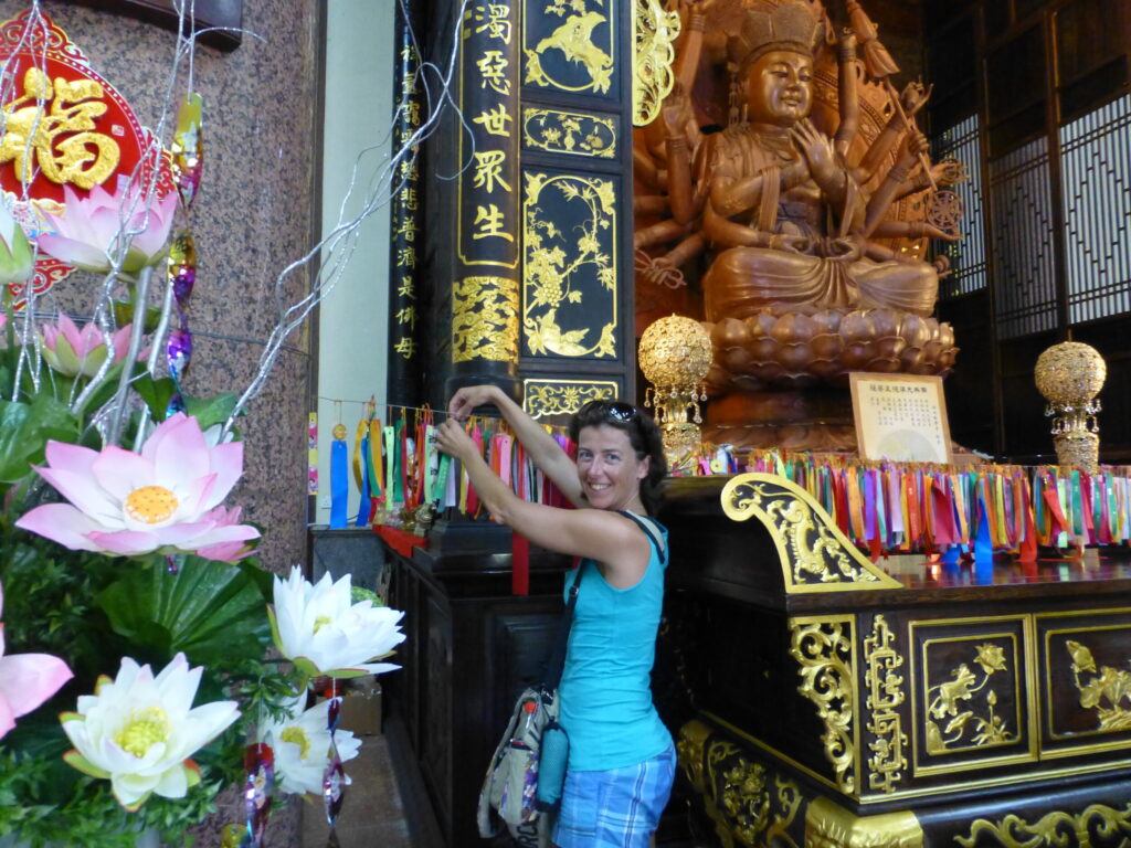 Een lintje ophangen in de Kek Lok Si Tempel in 2014 - Penang